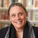 A headshot of Laurie L. Patton. Patton has pale skin, blue eyes, and graying hair, and wears a dark coat.