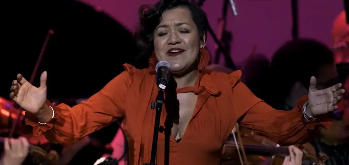 Martha Gonzalez Singing at a Microphone on Stage