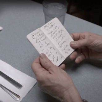 Small notebook with writing held by author Eileen Myles.