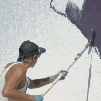 Muralist Yatika Starr Fields painting a wall