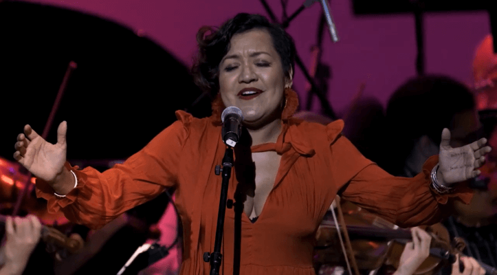 Martha Gonzalez Singing at a Microphone on Stage