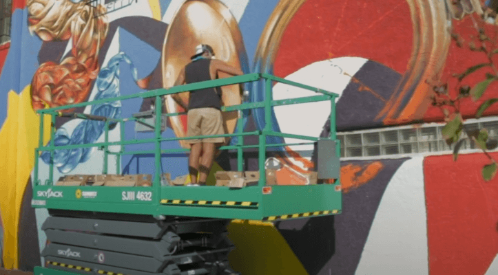Muralist Yatika Starr Fields painting a wall