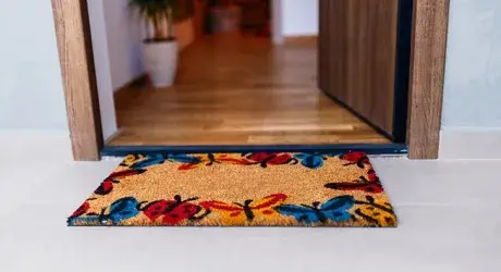 Entry to a home with doormat and open doorway. 