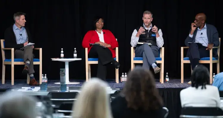 Four adults on stage during a panel
