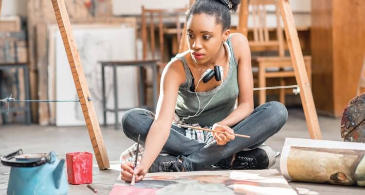 Woman Sitting on the Floor Painting a Canvas