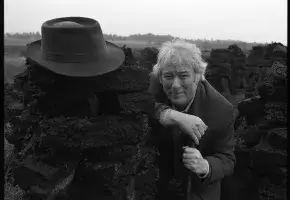 Seamus Heaney at a turf bog in Bellaghy with his father's coat, hat and walking stick and additional shots in the Bellaghy bog, 1986.  Bobbie Hanvey, photographer.