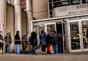 People in long line at a courthouse door. 
