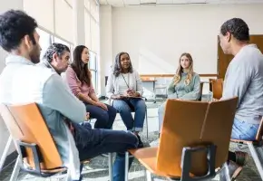 Small group discussion with people seated in chairs. 