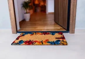 Entry to a home with doormat and open doorway. 