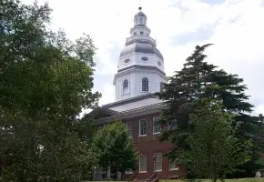 Maryland State House with trees in foreground. 