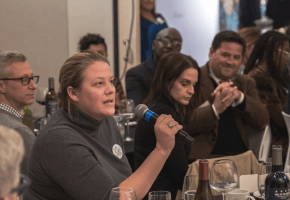 Seated woman speaks into microphone at event about democracy in Lexington, Kentucky