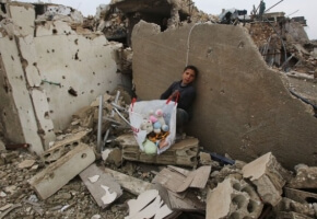 A Syrian boy sits with belongings he collected from the rubble of his house in Aleppo's Al-Arkoub neighbourhood on Dec. 17, 2016, after pro-government forces retook the area from Syrian rebel fighters.