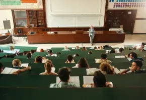 A professor stands at the front of an amphitheater.