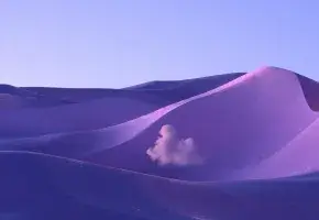 Image of purple sand dune against a blue-purple sky. 