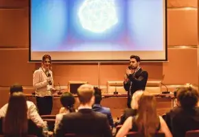 Two People Giving a Presentation Before a Scientific Image