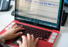 Hands on a red laptop keyboard. 