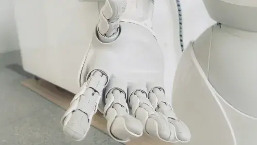 White robotic hand with open palm reaching out. 